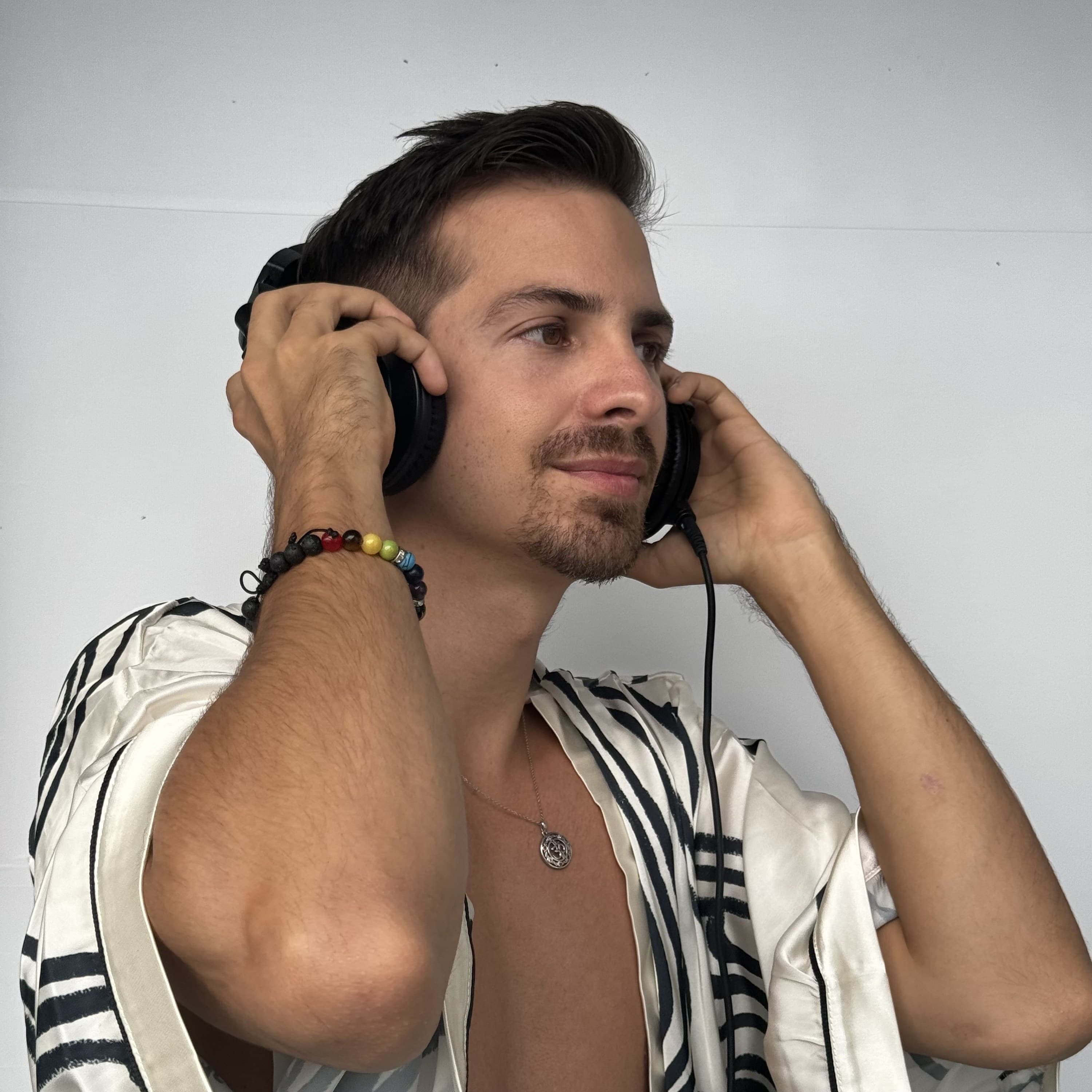 Headshot of Mike Mana holding his headphones